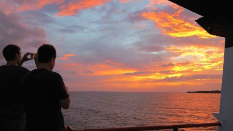 Tourists on a ferry headed to Ometepe Island in Lake Nicaragua snap photos of a spectacular sunset on August 12, 2014. The island, dominated by two volcanoes, is growing as a tourist destination. 