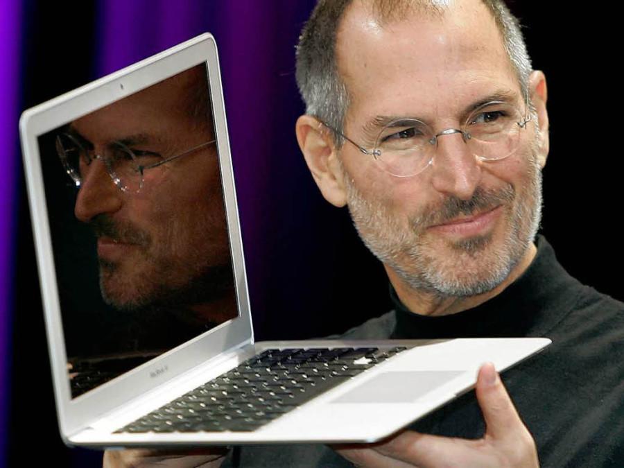 Steve Jobs holding one of the many Apple products he helped create. 