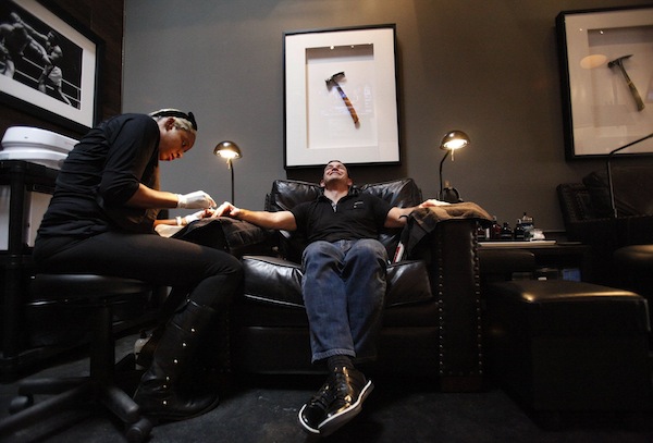 Rick Andreoli, right, has his nails done by Naima Malone at the media opening for Hammer and Nails which bills itself as the first nail shop for men in Los Angeles, Nov. 7, 2013. (Bob Chamberlin/Los Angeles Times/MCT)
