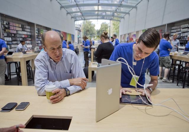 Apple Genius Daniel Brewster, right, helps Chris Berka, of Portola Valley, with a start-up problem on his MacBook Pro at the Apple Store in Palo Alto, Calif., May 20, 2014. (LiPo Ching/Bay Area News Group/MCT)