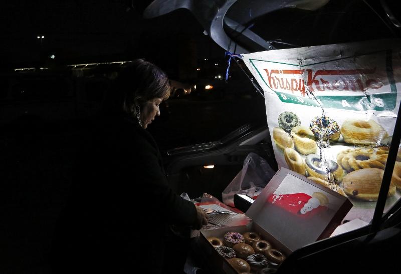 Sonia Garcia sells Krispy Kreme doughnuts, purchased across the border in El Paso, Texas from the trunk of her car on a busy street in Ciudad Juarez, Mexico. The money she and her family make selling doughnuts helps pay for her son to go to college. (Katie Falkenberg/Los Angeles Times/TNS)