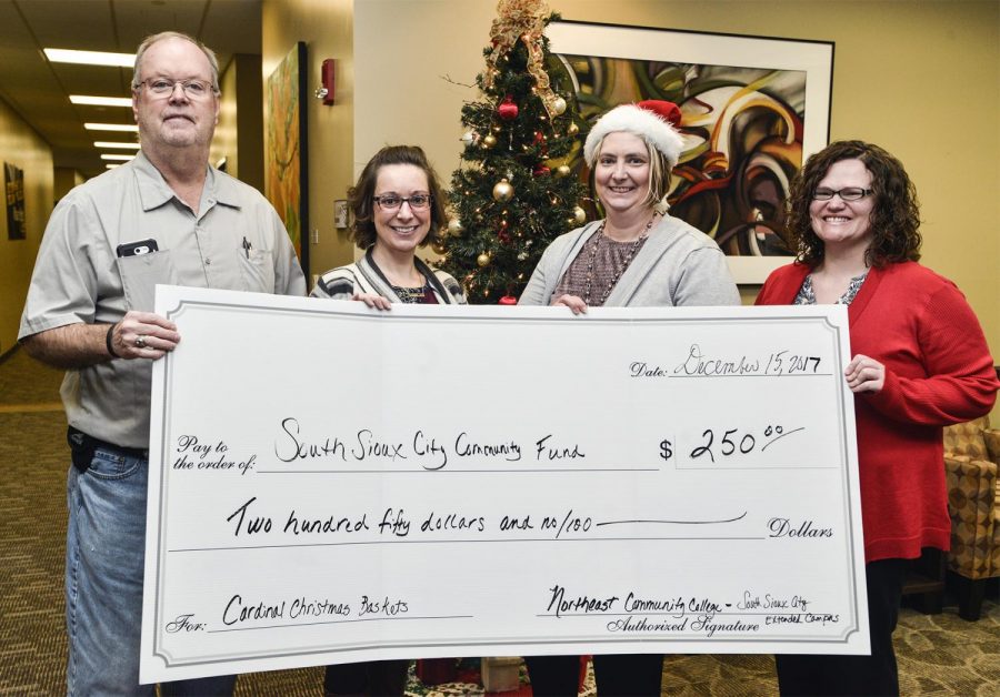 Bill Garvey Sr., co-chair of the Cardinal Christmas Baskets program, accepts a check for $250 from Northeast Community College representatives Kristina Coombs, service center specialist (left), Dr. Cyndi Hanson, executive director, and Cara Watchorn, student support specialist. The funds were raised by allowing Northeast employees to pay to wear jeans on certain Fridays throughout the past year.